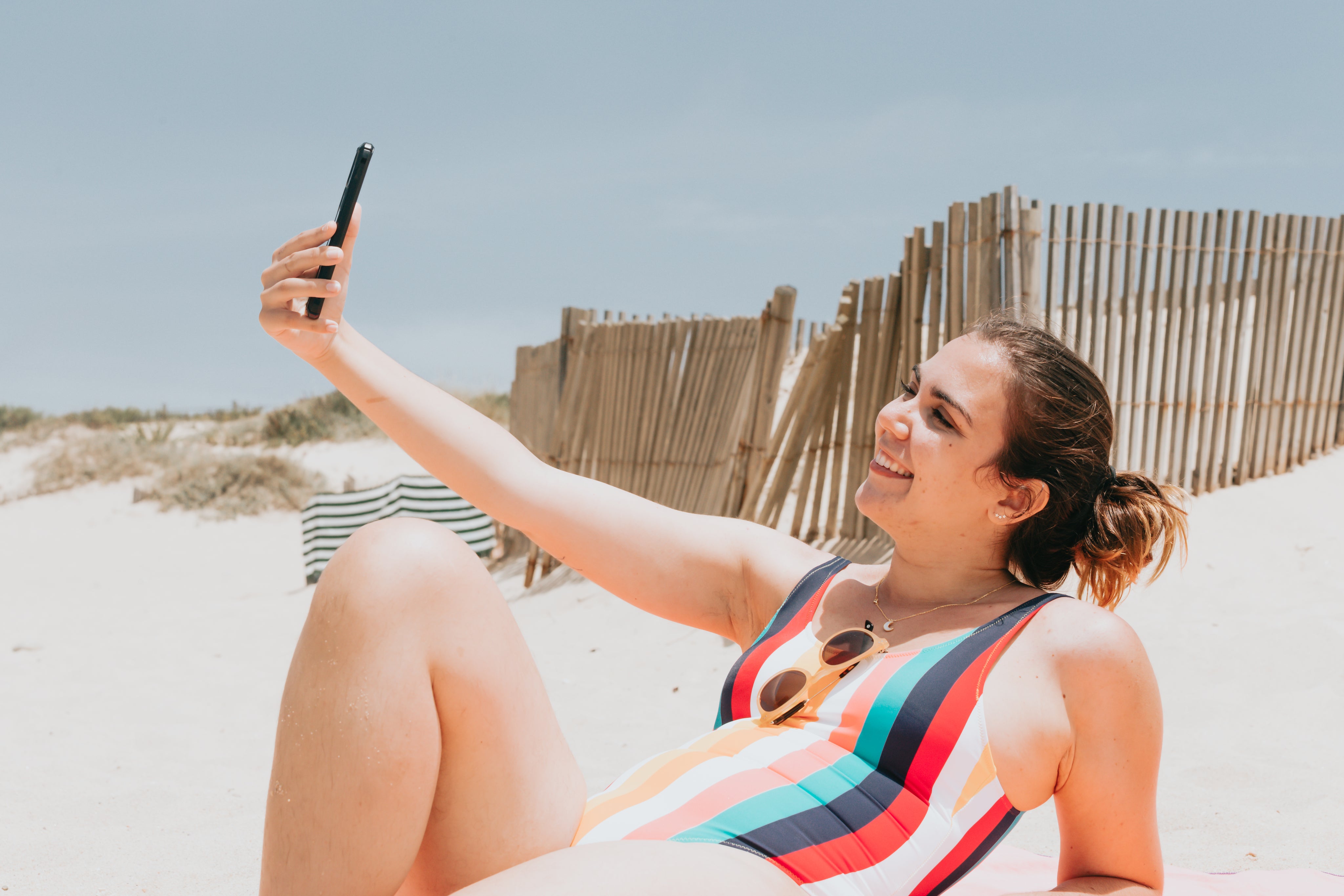 files/woman-in-striped-bathing-suit-takes-a-beach-selfie.jpg